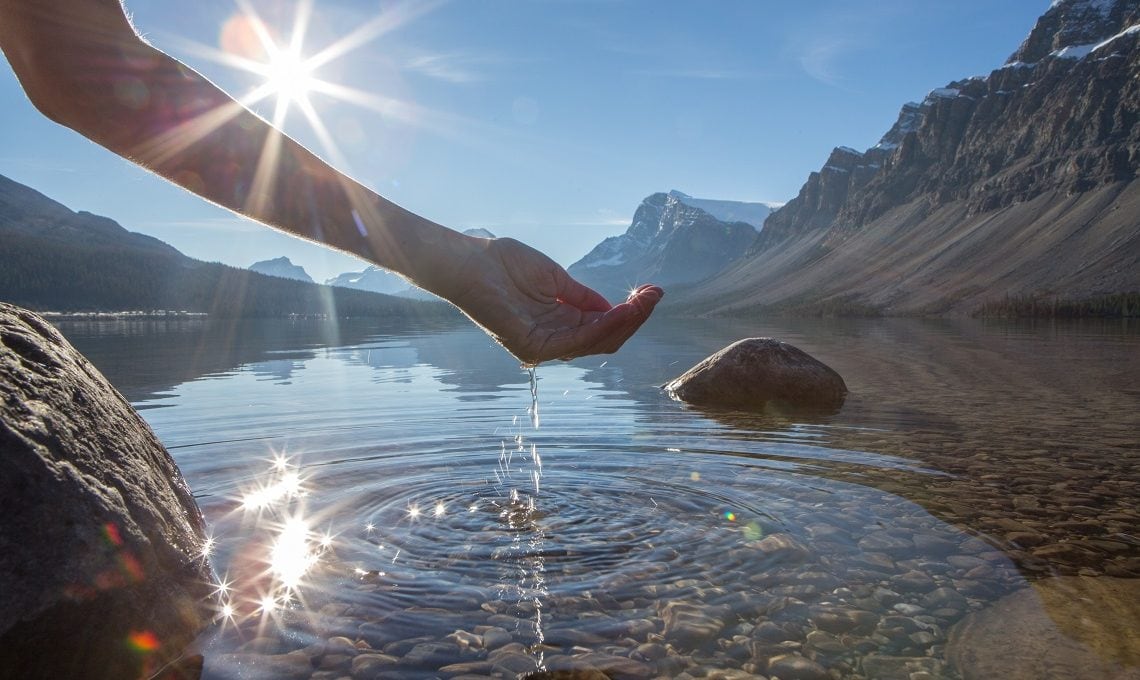 Human hand cupped to catch the fresh water from lake